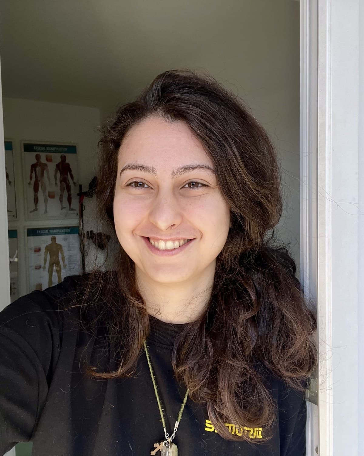 Dr. Amelia Voinea in cabinetul ei, cu plansele de manipulare fasciala pe perete